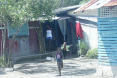 Hütten im Dorf Asencion, die Kinder rennen auf den Weg